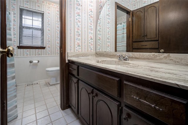 bathroom with tile patterned floors, vanity, and toilet