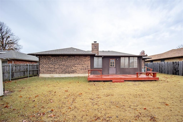 back of house featuring a lawn and a wooden deck