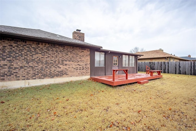 back of property with a lawn and a deck