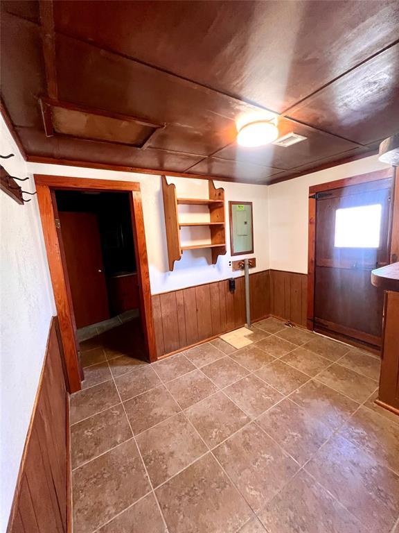 kitchen with wooden ceiling, electric panel, and wooden walls