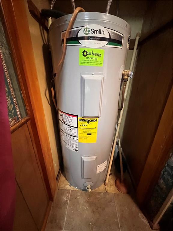 utility room featuring water heater