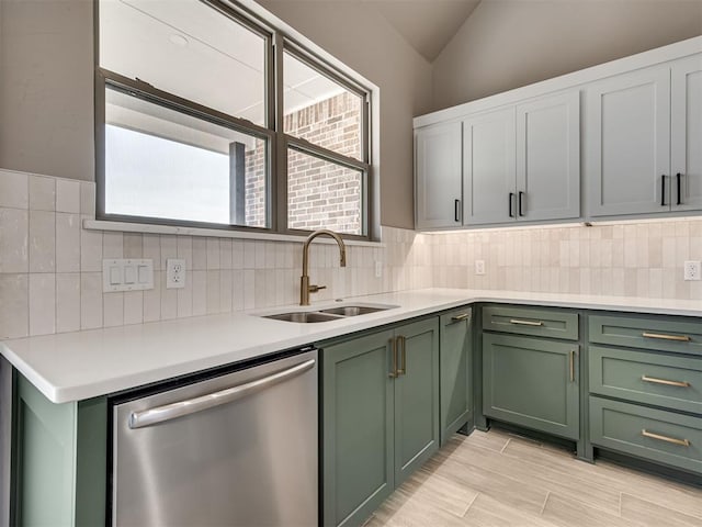 kitchen featuring backsplash, vaulted ceiling, sink, green cabinetry, and dishwasher