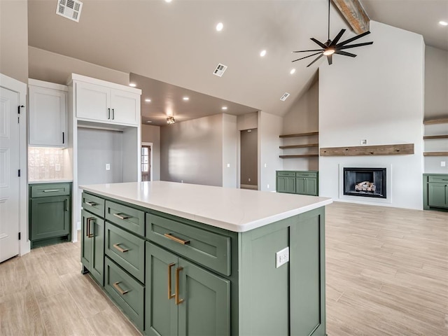 kitchen featuring white cabinets, a center island, ceiling fan, and green cabinets