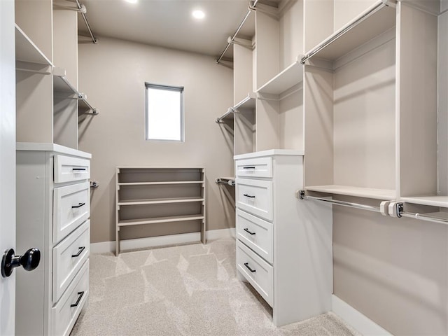 walk in closet featuring light carpet