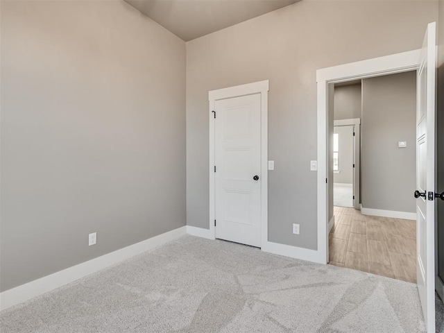 unfurnished bedroom featuring a closet and light colored carpet