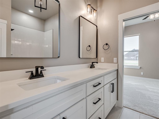 bathroom with tile patterned flooring, vanity, and ceiling fan