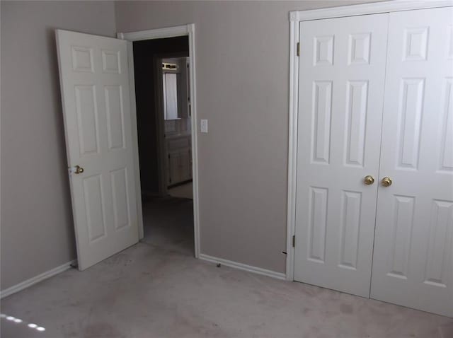 unfurnished bedroom featuring light carpet and a closet