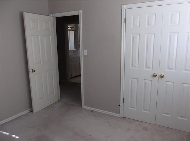 unfurnished bedroom with light carpet and a closet