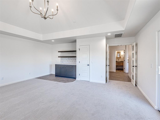 unfurnished living room with light carpet and a notable chandelier