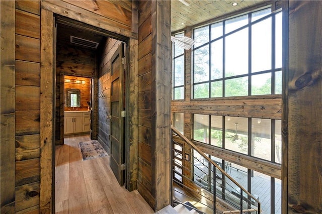 hallway with wood-type flooring and wooden walls