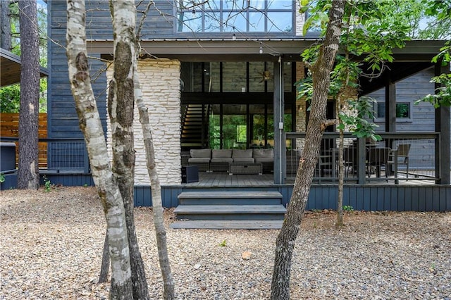 view of exterior entry with outdoor lounge area and a deck