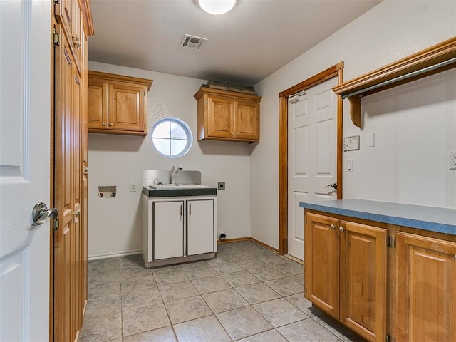 washroom with sink, light tile patterned floors, electric dryer hookup, cabinets, and washer hookup