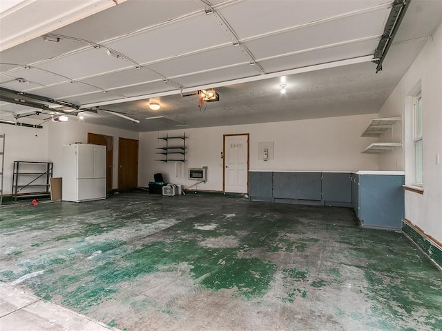 garage featuring white refrigerator and electric panel