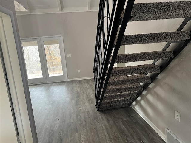 staircase with beam ceiling and hardwood / wood-style floors