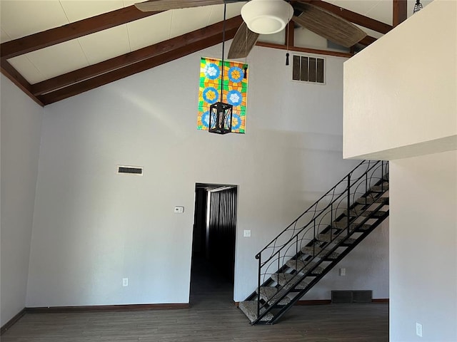 stairs featuring hardwood / wood-style flooring, ceiling fan, beam ceiling, and high vaulted ceiling