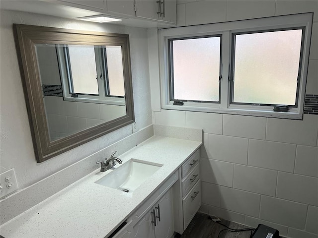 bathroom featuring vanity and tile walls