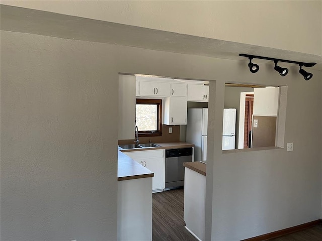 kitchen featuring dishwasher, dark hardwood / wood-style floors, white cabinetry, and sink