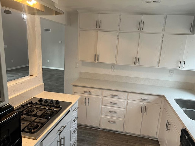 kitchen with white cabinets, dark hardwood / wood-style flooring, gas cooktop, and black dishwasher