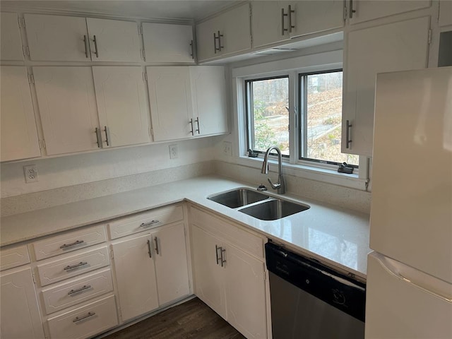 kitchen featuring stainless steel dishwasher, white fridge, white cabinetry, and sink