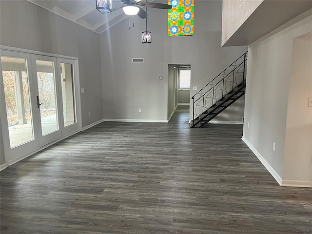 unfurnished living room with ceiling fan, plenty of natural light, and dark wood-type flooring