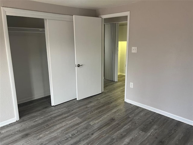 unfurnished bedroom featuring a closet and dark hardwood / wood-style floors