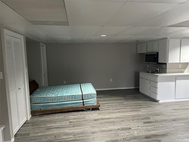 unfurnished bedroom featuring sink and light hardwood / wood-style floors