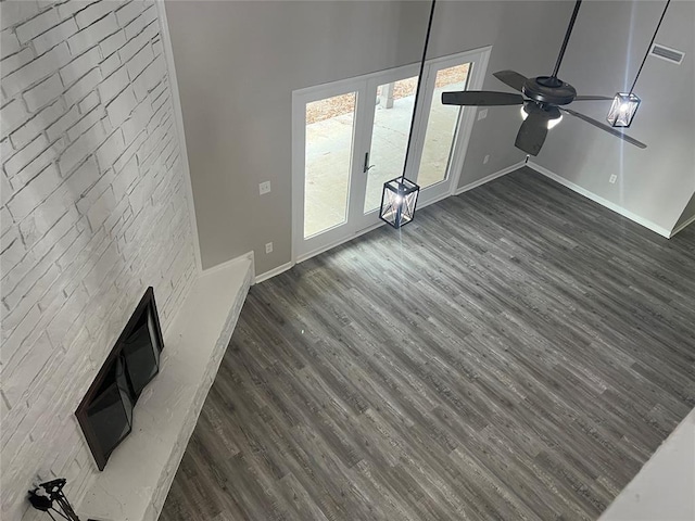 unfurnished living room featuring ceiling fan, a towering ceiling, and dark hardwood / wood-style floors