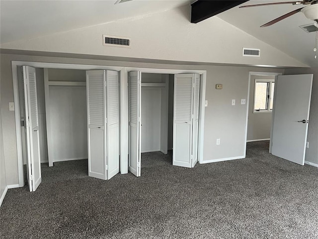 unfurnished bedroom featuring vaulted ceiling with beams, ceiling fan, dark carpet, and multiple closets