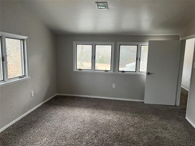 carpeted empty room featuring a textured ceiling