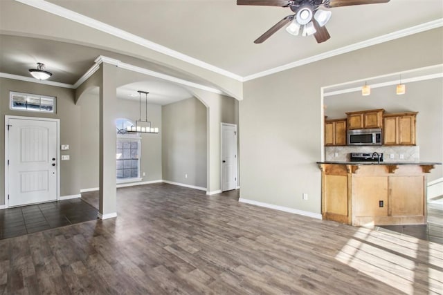 kitchen featuring decorative backsplash, crown molding, dark hardwood / wood-style flooring, and appliances with stainless steel finishes