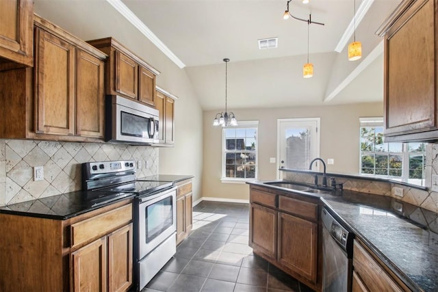 kitchen featuring pendant lighting, an inviting chandelier, sink, vaulted ceiling, and appliances with stainless steel finishes