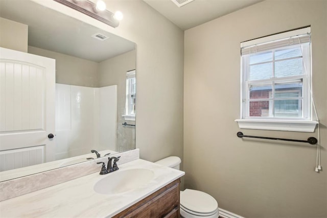 bathroom with a shower, plenty of natural light, vanity, and toilet