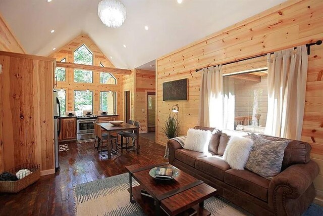 living room with high vaulted ceiling, dark wood-type flooring, and wood walls