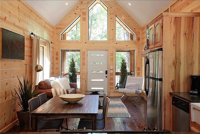 dining space with dark hardwood / wood-style flooring, high vaulted ceiling, and plenty of natural light