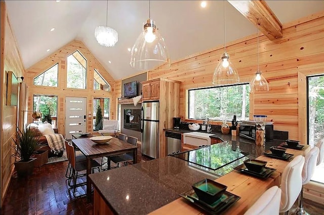 kitchen featuring pendant lighting, beam ceiling, dark hardwood / wood-style flooring, and appliances with stainless steel finishes