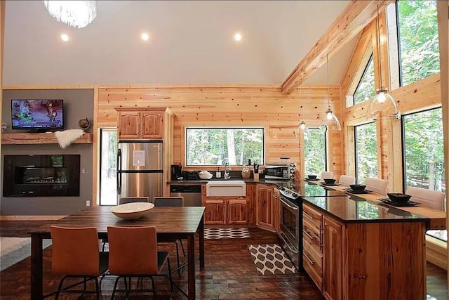 kitchen with appliances with stainless steel finishes, dark wood-type flooring, sink, beam ceiling, and high vaulted ceiling