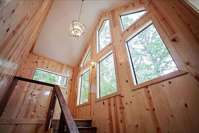 interior space featuring wood walls, plenty of natural light, and high vaulted ceiling