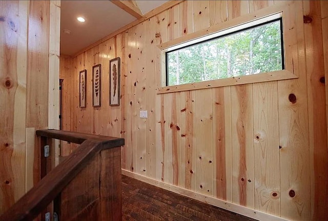 hall with dark hardwood / wood-style floors and wood walls