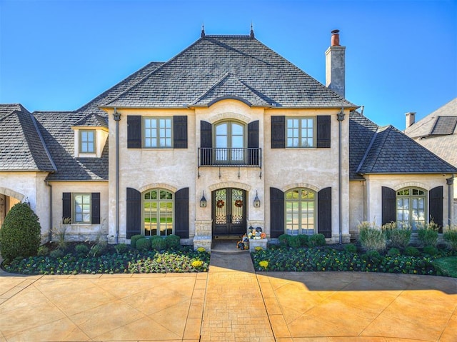 french country home with french doors and a balcony