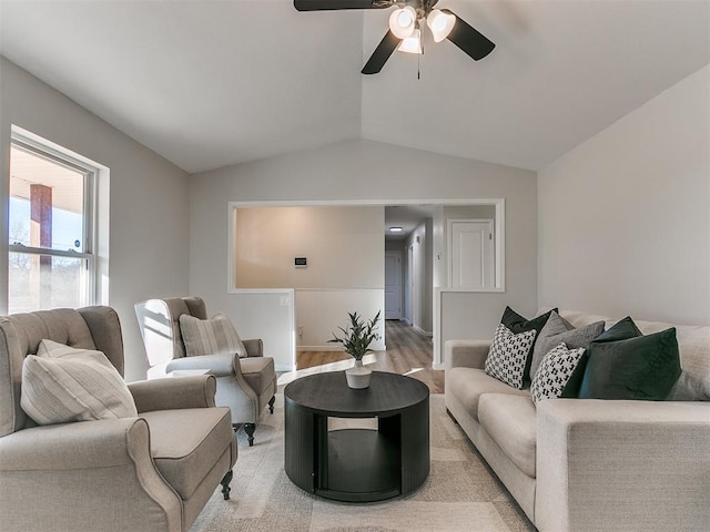 living room featuring ceiling fan, light hardwood / wood-style flooring, and lofted ceiling