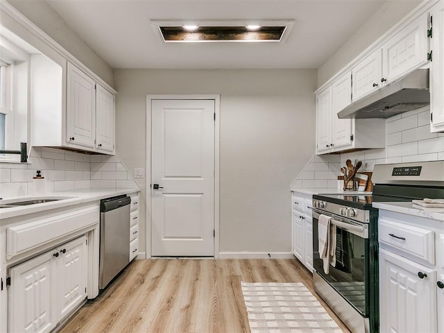 kitchen featuring decorative backsplash, light hardwood / wood-style flooring, white cabinets, and appliances with stainless steel finishes