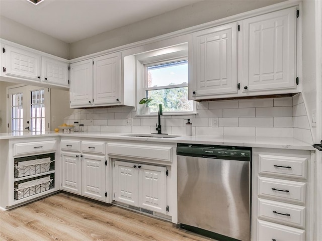 kitchen featuring dishwasher, decorative backsplash, white cabinetry, and sink