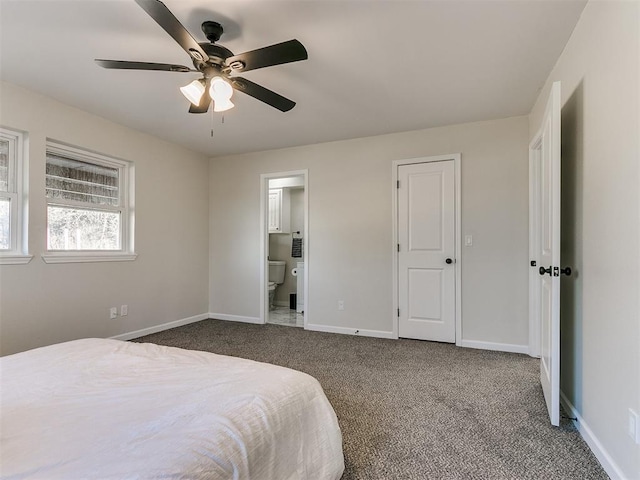 bedroom with ensuite bath, dark carpet, and ceiling fan