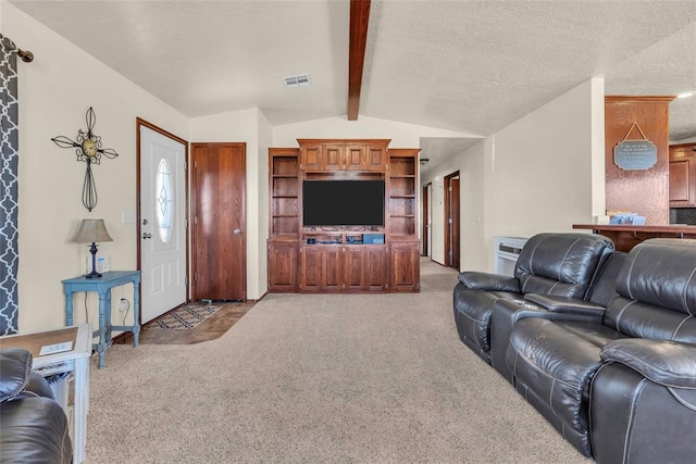 carpeted living room with a textured ceiling and lofted ceiling with beams