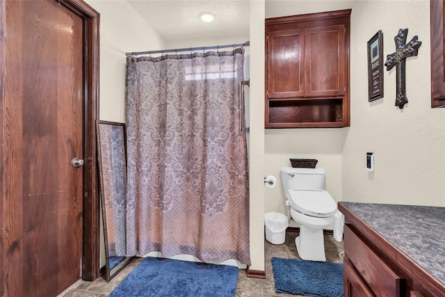 bathroom featuring a shower with curtain, vanity, and toilet