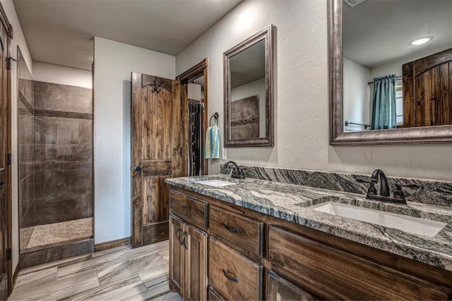 bathroom with vanity and a tile shower