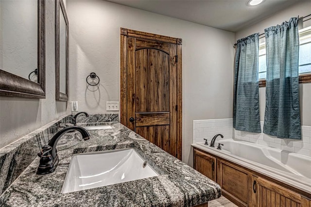 bathroom featuring vanity and a bath