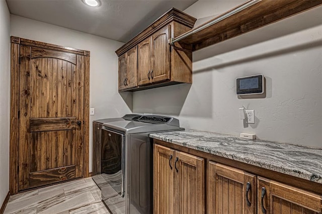 washroom featuring washing machine and clothes dryer and cabinets