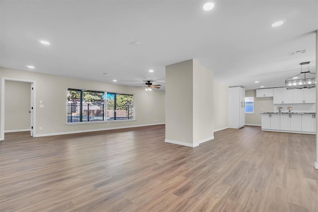 unfurnished living room featuring light hardwood / wood-style floors and ceiling fan