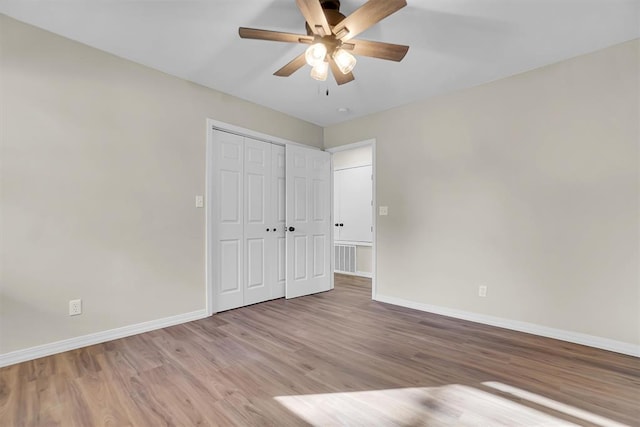 unfurnished bedroom featuring ceiling fan, a closet, and light hardwood / wood-style floors